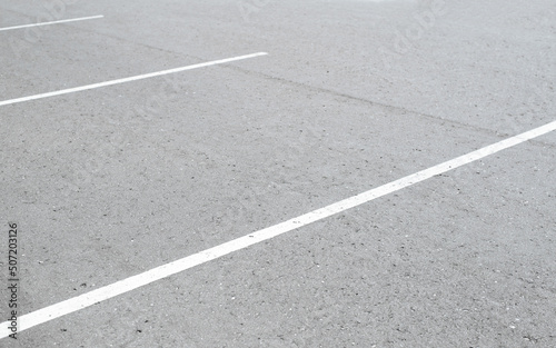 White marking lines on asphalt in an empty parking lot, outdoors