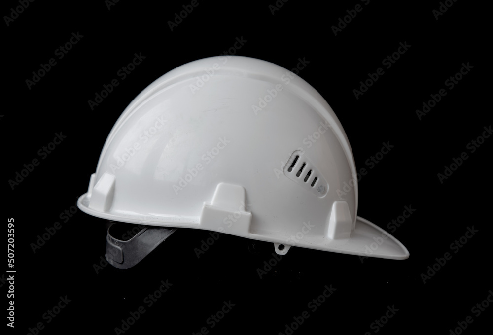 White construction helmet on a black background. White construction helmet on a black background.