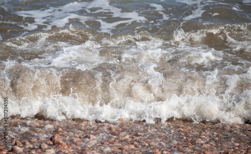Fototapeta Naklejka Na Ścianę i Meble -  foamy coastal sea wave of a pebble beach