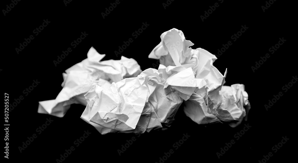 A piece of crumpled white paper on a black background. A piece of crumpled white paper on a black background.