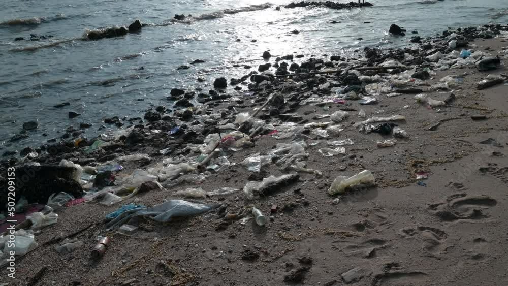 Beach pollution. Lots of Trash, plastic bottles and litter on the coastline..