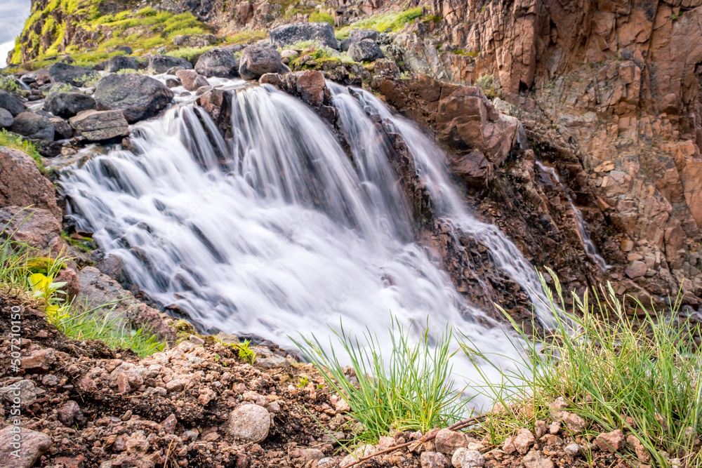 Obraz premium Summer polar landscape with waterfall in Teriberka. Kola Peninsula of the Barents Sea. The nature of the north of Russia