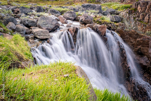 Summer polar landscape with waterfall in Teriberka. Kola Peninsula of the Barents Sea. The nature of the north of Russia