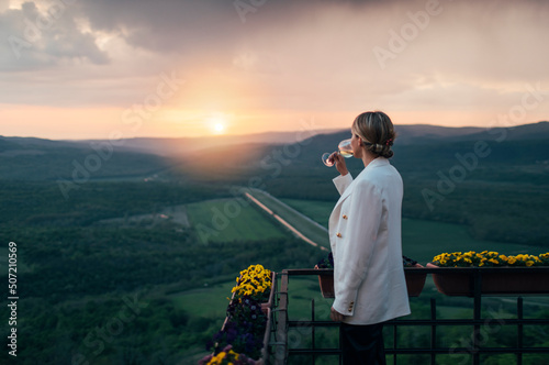 Side view of woman drinking white wine at viewpoint photo