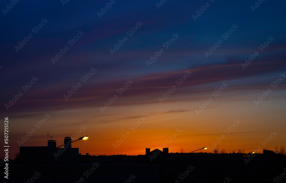 Beautiful bright sunset over the silhouettes of buildings