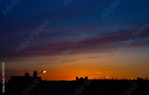 Beautiful bright sunset over the silhouettes of buildings