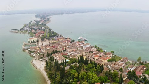Aerial view of historic island of Sirmione in Lake Garda Italy ancient village in south of lake travel destination beautiful natural view of reservoir city on water drone view Rocca Scaliger castle photo