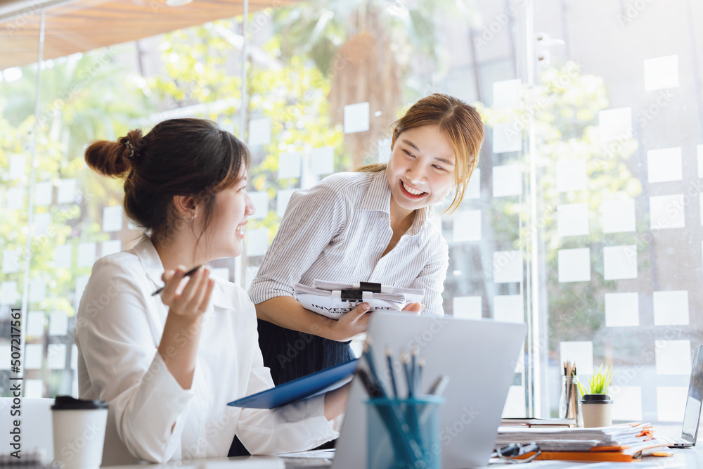 Obraz premium Negotiation, Analysis, Discussion: Portrait of an Asian woman economist and marketer pointing to a financial data sheet to plan investments to prevent risks and losses for the company
