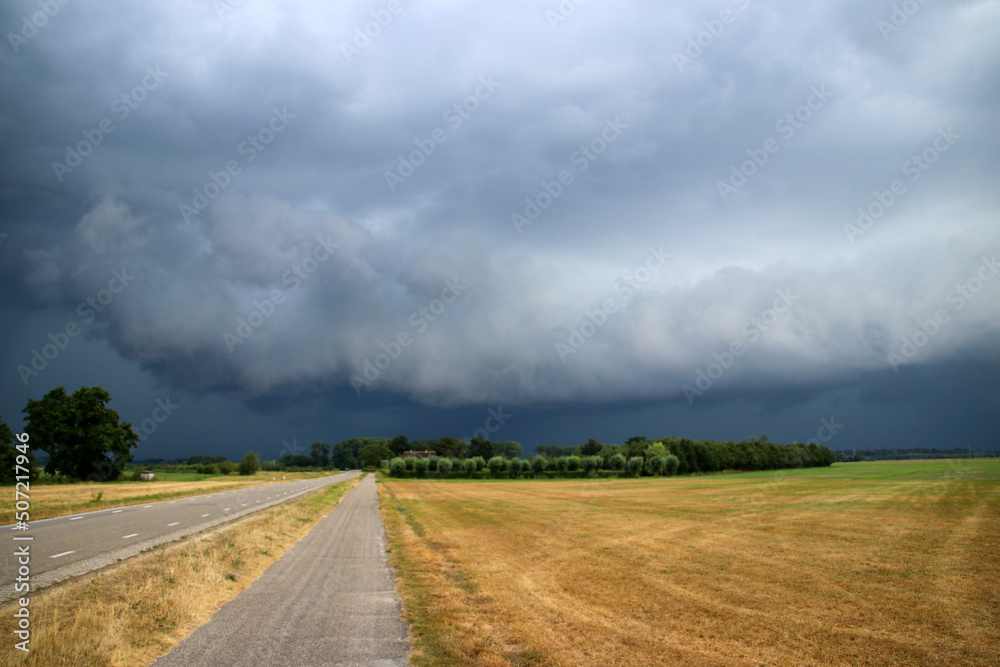 Big wall cloud above the fields in Overijssel in the Netherlands with thunderstorms coming up Big wall cloud above the fields in Overijssel in the Netherlands with thunderstorms coming up