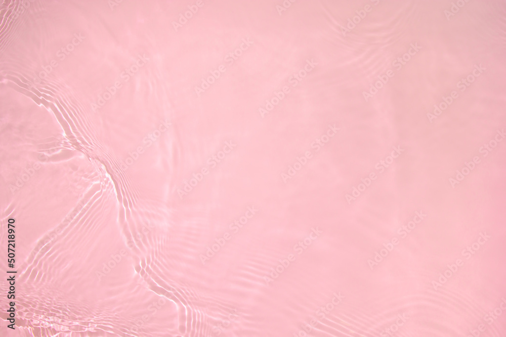 Fototapeta premium Transparent pink colored clear water surface texture with ripples, splashes and bubbles. Abstract nature background Water waves in sunlight with copy space Cosmetic moisturizer micellar toner emulsion