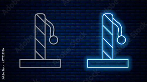 Glowing neon line Cat scratching post with toy icon isolated on brick wall background. Vector