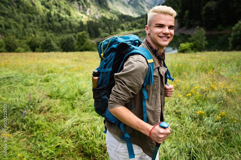 Young man traveling with backpack hiking in mountains