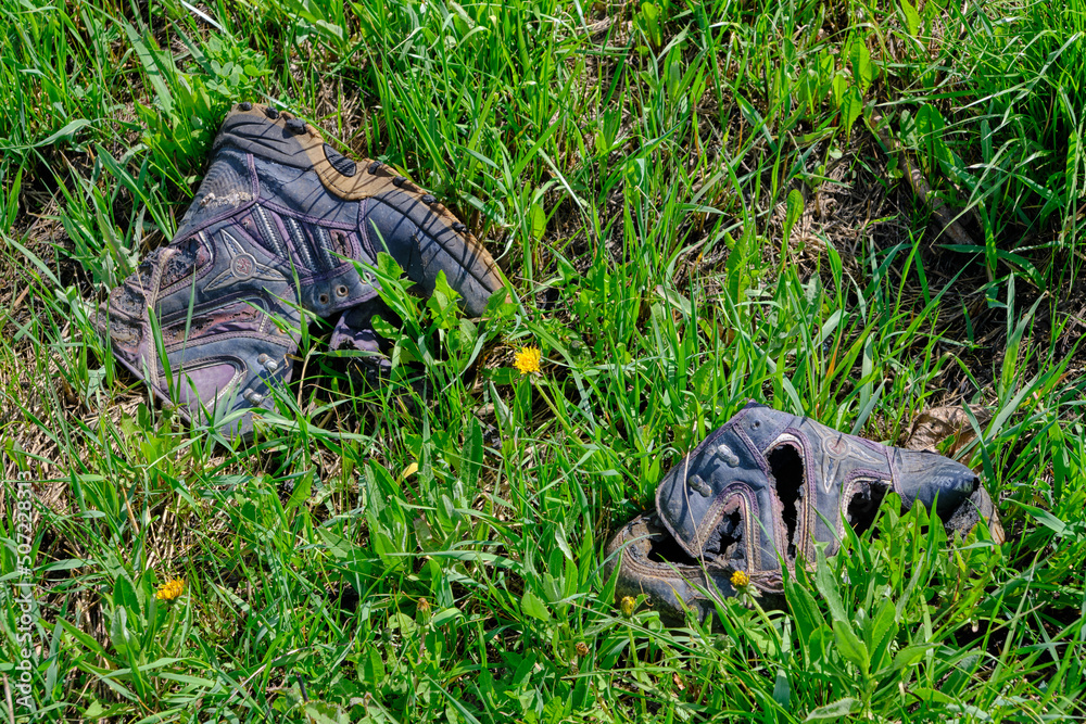 Discarded old rotten shoes, pollution of ecology and nature.