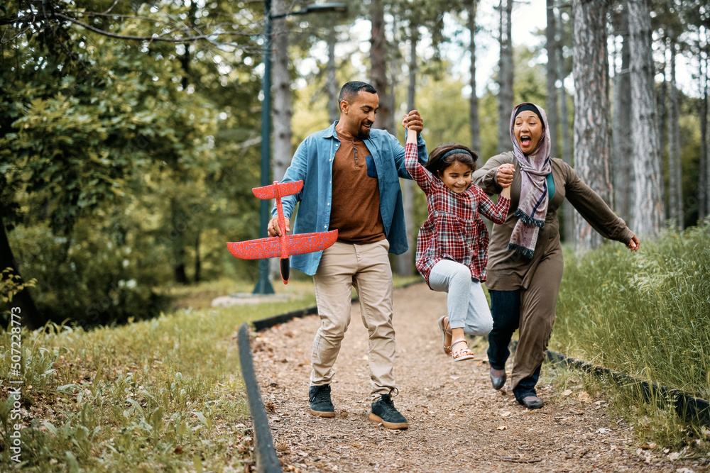 Playful Muslim family has fun while walking in nature. Playful Muslim family has fun while walking in nature.