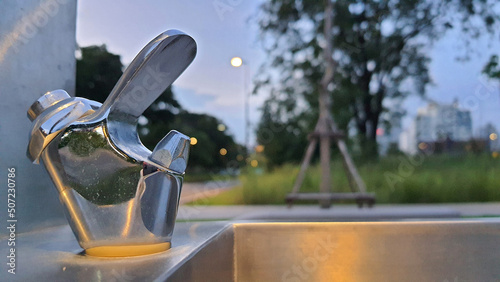 Water tap or drinking fountain for drinking at public park with some stain. Spot focus © Runglawan