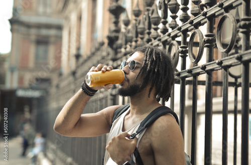 young man drinks a beer on the street