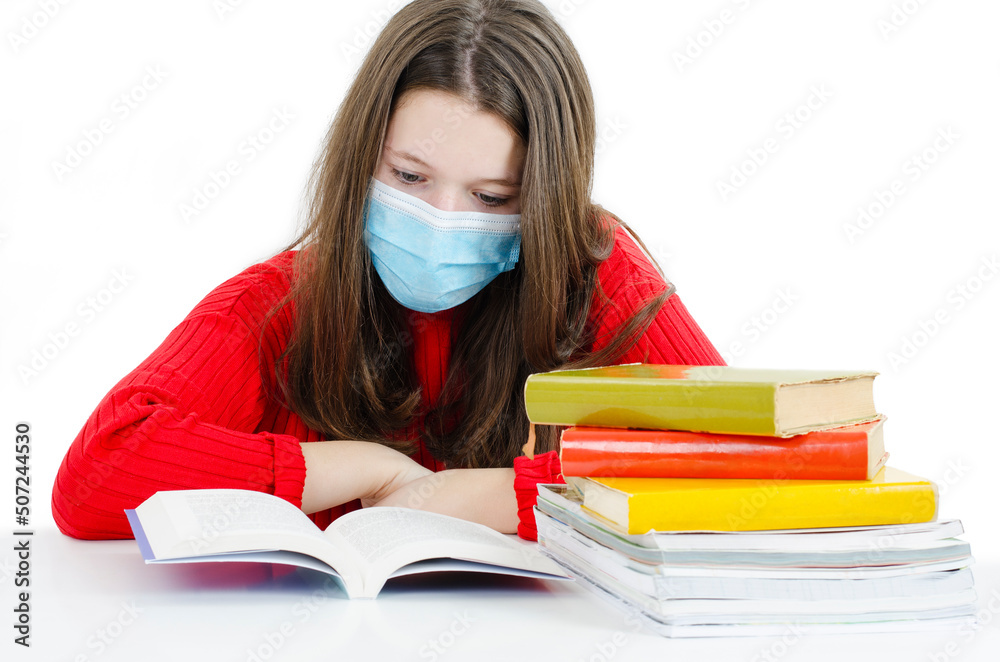 Young student in protective mask with books. Isolated on white background. Pupil girl, teenage girl in protective medical mask on face, reading. Protection during epidemic influenza and coronaviruses.