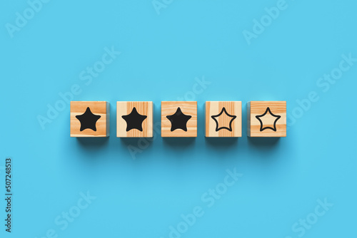 Three star rating. Wooden blocks with stars on a blue background. 3d rendering.