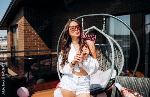 Happy bride celebrates bachelorette party, dancing and having fun on the roof of the house.