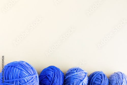 Blue balls of knitting threads on a yellow background for knitting warm clothes