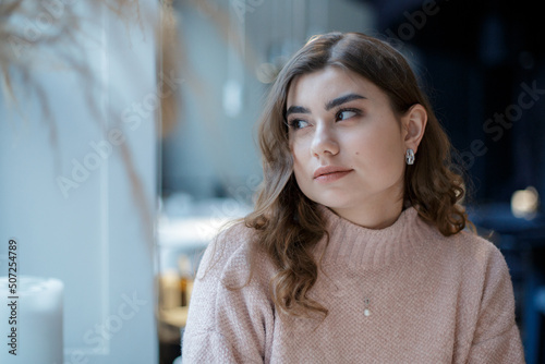 Romantic casual woman portrait. Woman at a cafe, sad alone girl.