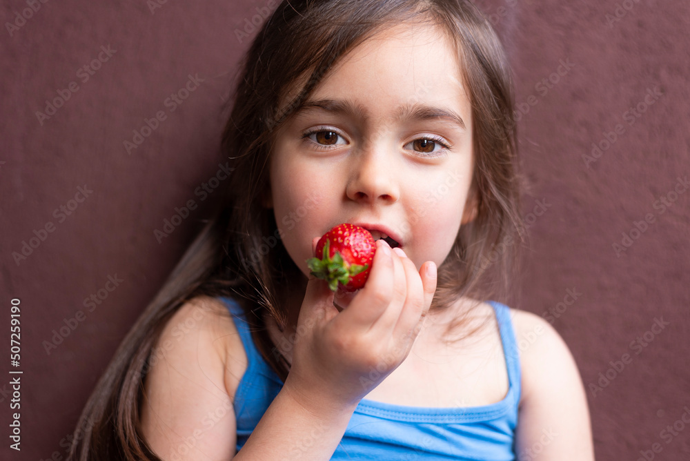 Young girl eats fresh red strawberry Young girl eats fresh red strawberry