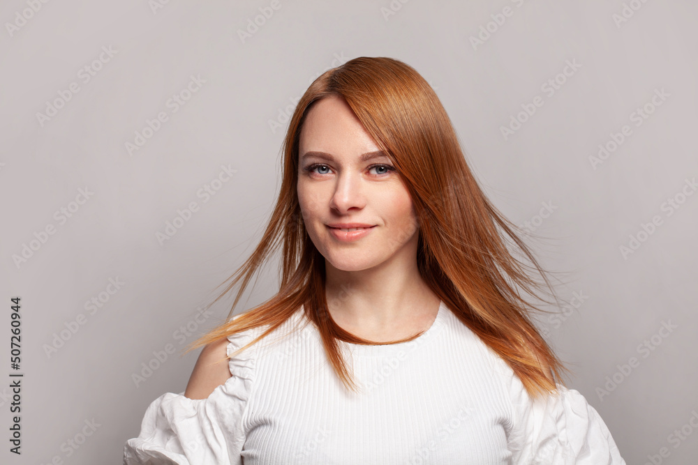 Cheerful woman with red ginger hairstyle posing on grey studio background Cheerful woman with red ginger hairstyle posing on grey studio background