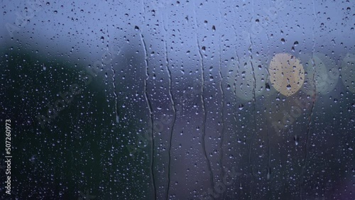 Moody rain on window during storm with bokeh traffic lights photo