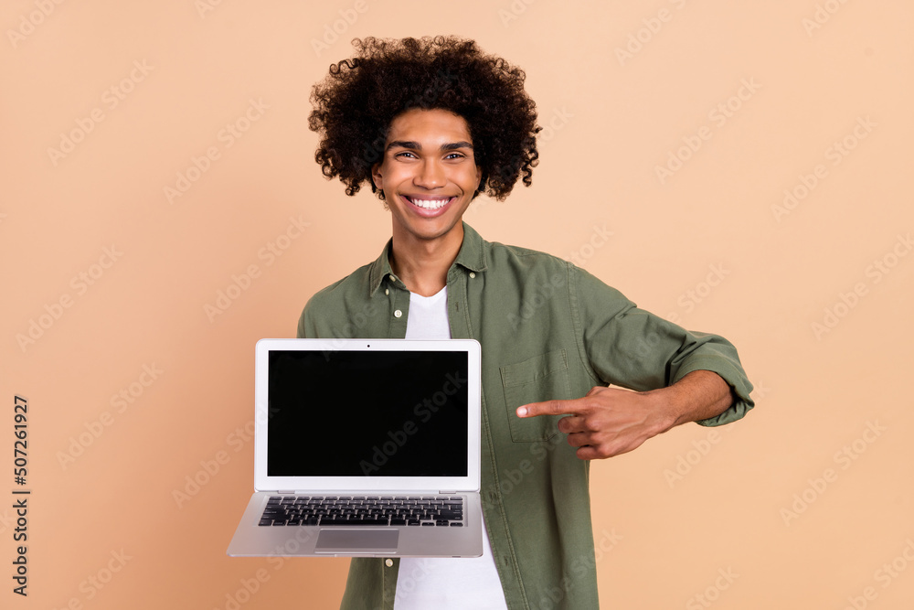 Portrait of handsome curly hairstyle guy direct finger empty space display isolated on beige color background Portrait of handsome curly hairstyle guy direct finger empty space display isolated on beige color background