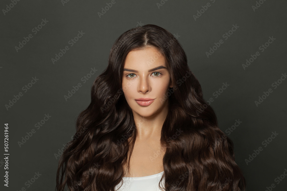 Brunette woman with perfect long volume shiny wavy hair portrait
