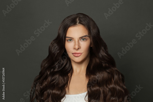Brunette woman with perfect long volume shiny wavy hair portrait