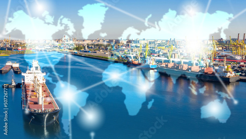 Ship in cargo port. Sea port with cranes for loading. Lines on map are metaphor for supply chains. Logistics sea freight transfers. World map in front of cargo port. International import and export