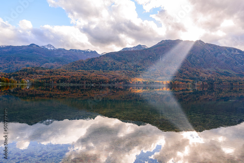 Autumn landscape by the lake Bohinj in Julian Alps. Fascinating reflectins in the lake on a cloudy day.