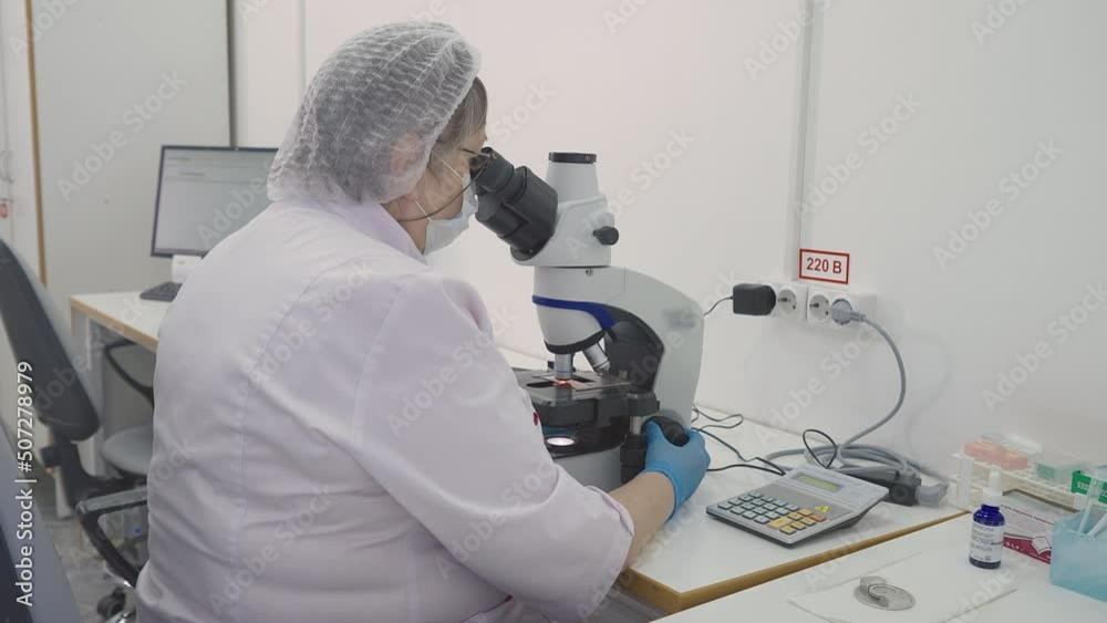 Medical Researcher Uses Microscope Instrument To Conduct Blood Test For Patients. Analysis Of Blood By Microscope. Health Test. Blood Test Examination. Microscope For Material Analysis. Laboratory Medical Researcher Uses Microscope Instrument To Conduct Blood Test For Patients. Analysis Of Blood By Microscope. Health Test. Blood Test Examination. Microscope For Material Analysis. Laboratory