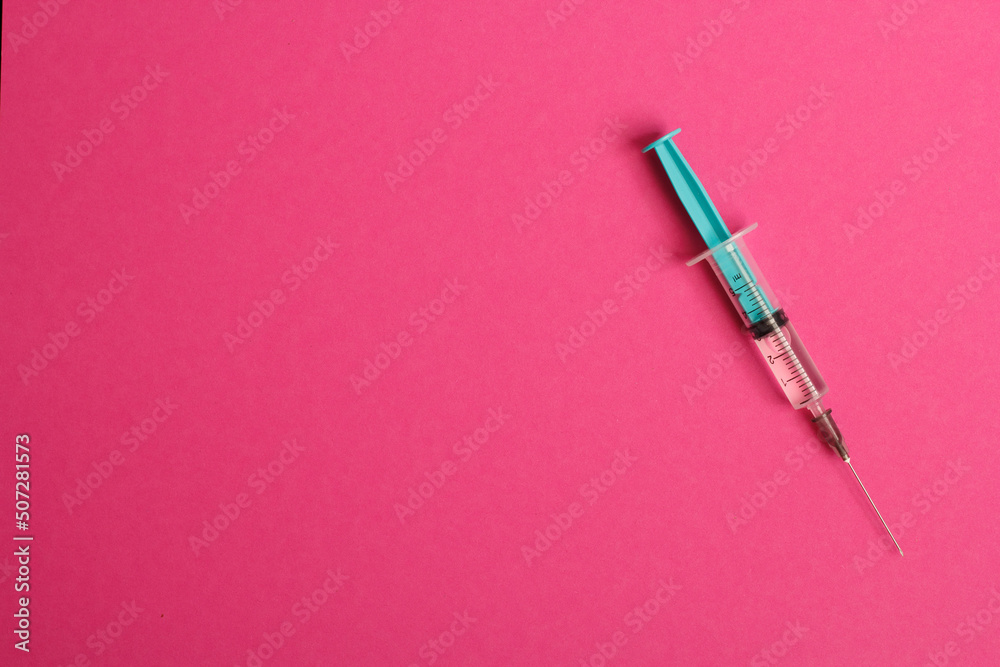 Medical syringe on a pink background. A syringe for injection. The concept of health and beauty Medical syringe on a pink background. A syringe for injection. The concept of health and beauty