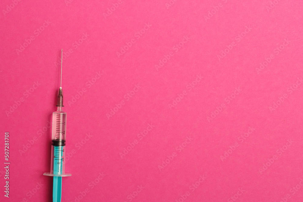 Medical syringe on a pink background. A syringe for injection. The concept of health and beauty Medical syringe on a pink background. A syringe for injection. The concept of health and beauty