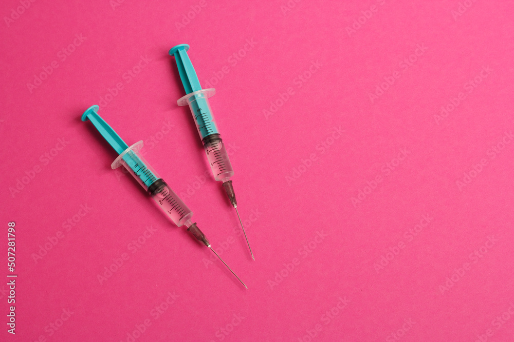 Medical syringe on a pink background. A syringe for injection. The concept of health and beauty Medical syringe on a pink background. A syringe for injection. The concept of health and beauty