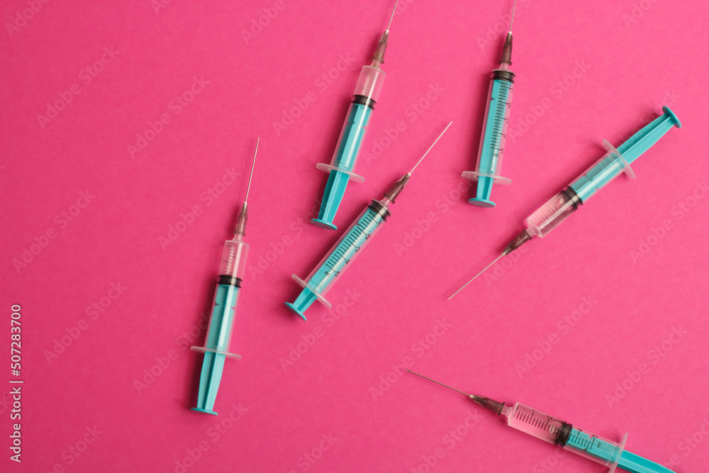 Medical syringe on a pink background. A syringe for injection. The concept of health and beauty Medical syringe on a pink background. A syringe for injection. The concept of health and beauty