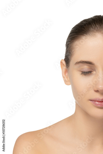Half-face portrait of young beautiful woman with perfect clean skin and no makeup isolated over white studio background