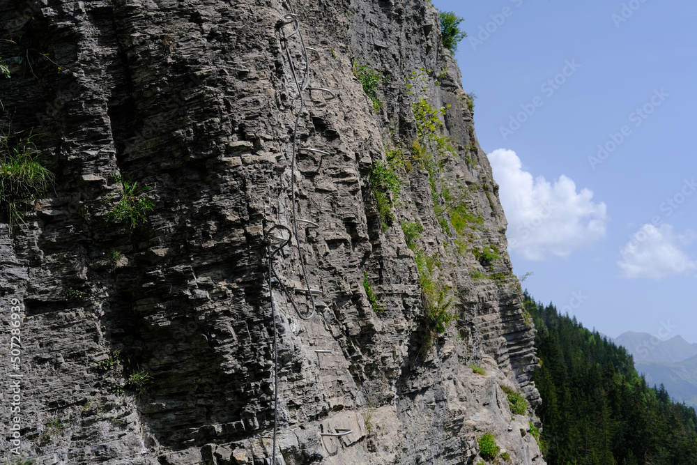 via ferrata on the rock, iron path for climbers on the mountain range in france, route in the Graian Alps, climbing the Mont Blanc rock, trails in summer, team support, extreme sport achievements