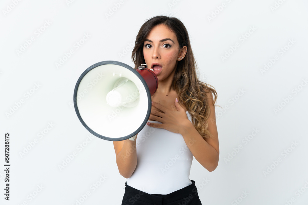 Young caucasian woman isolated on white background shouting through a megaphone with surprised expression Young caucasian woman isolated on white background shouting through a megaphone with surprised expression