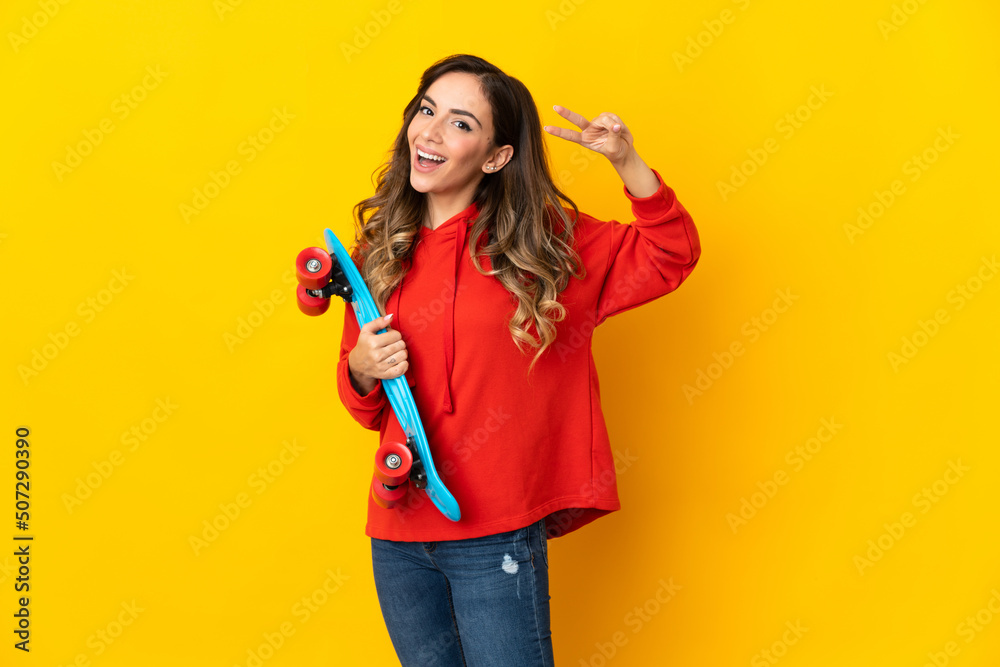 Young caucasian woman isolated on yellow background with a skate with happy expression Young caucasian woman isolated on yellow background with a skate with happy expression