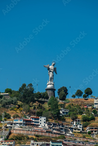 The statue of the Madonna at the top of the hill El Panecillo with blue sky background, Quito, Ecuador