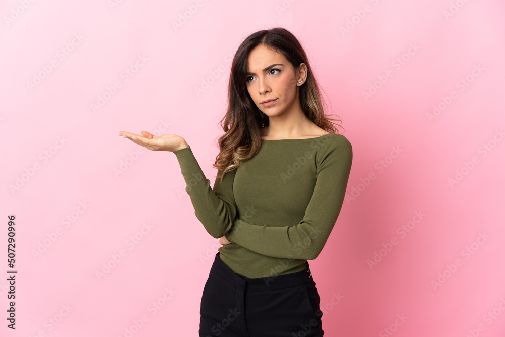 Young caucasian woman isolated on pink background having doubts Young caucasian woman isolated on pink background having doubts