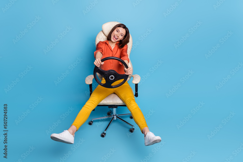 Full length body size view of attractive cheerful girly girl holding steering wheel fooling isolated over bright blue color background Full length body size view of attractive cheerful girly girl holding steering wheel fooling isolated over bright blue color background
