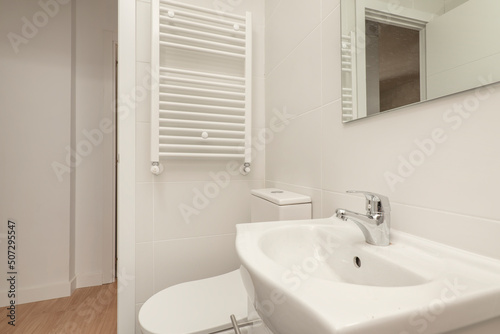 toilet with white wooden bathroom cabinet with frameless mirror  shower cabin with screen and wall tiled with hydraulic tiles
