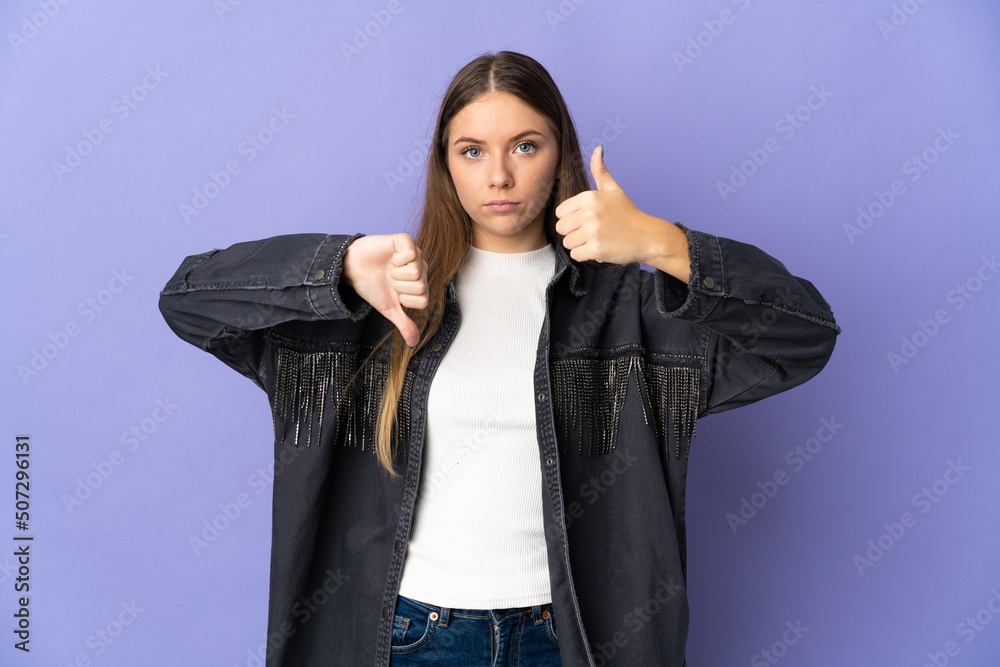 Young Lithuanian woman isolated on purple background making good-bad sign. Undecided between yes or not Young Lithuanian woman isolated on purple background making good-bad sign. Undecided between yes or not