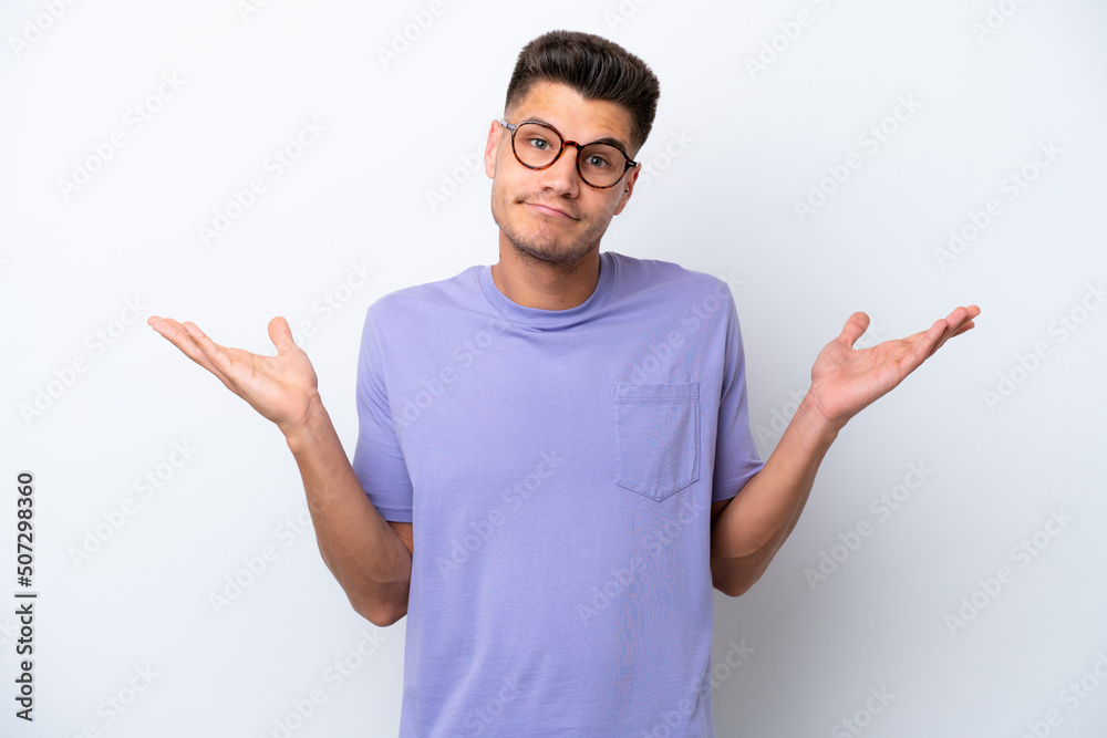 Young caucasian man isolated on white background having doubts while raising hands Young caucasian man isolated on white background having doubts while raising hands