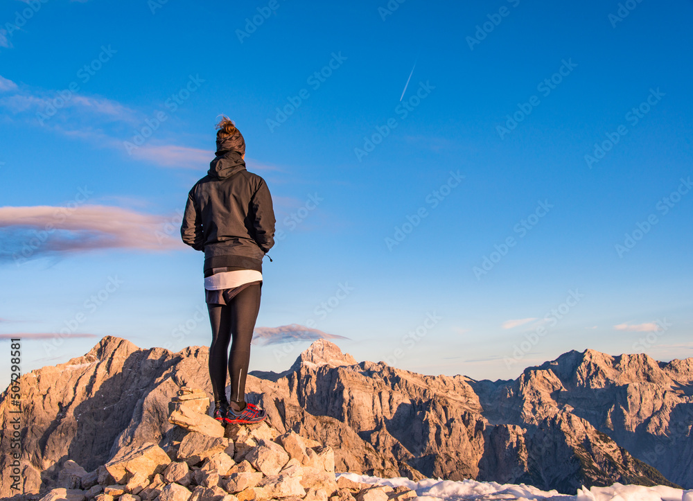 Male hiker in the vast mountain landscape at sunset. Beautiful mountain panorama in the evening in the Alps