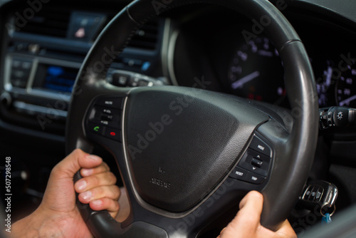 Hands of driving man on the road.